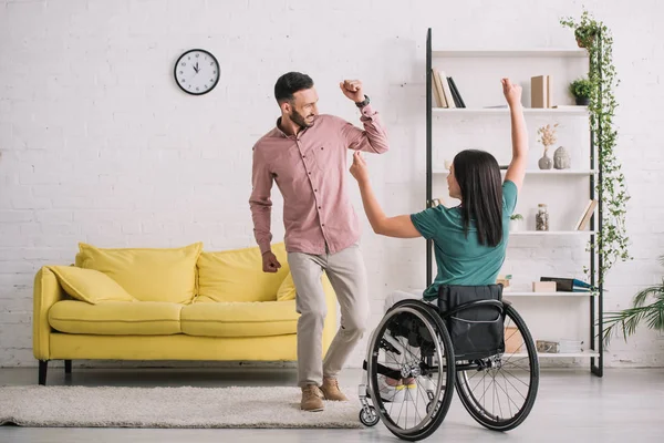 Rückansicht einer jungen behinderten Frau im Rollstuhl, die mit ihrem glücklichen Freund tanzt — Stockfoto
