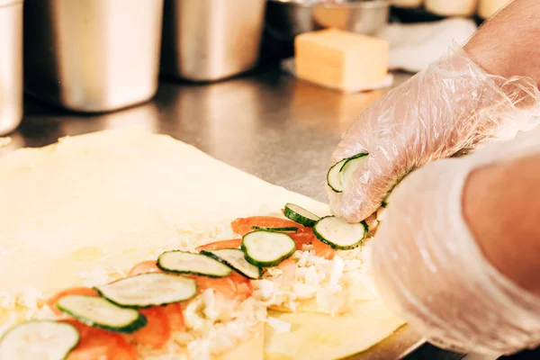 Vista parcial de cocinero en guantes preparando doner kebab - foto de stock