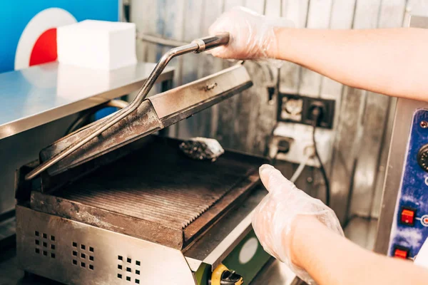 Vista parcial de cocinero en guantes cerca de parrilla de kebab - foto de stock