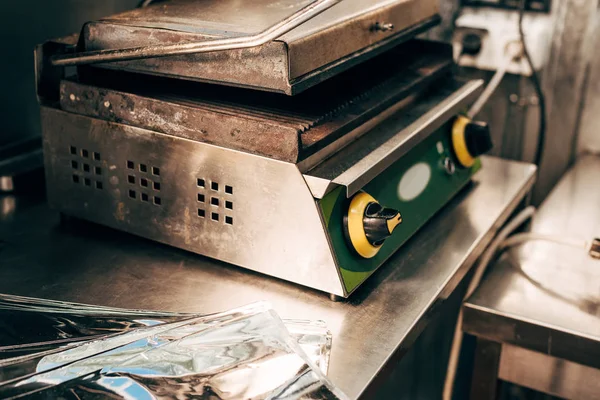 Folha de alumínio e churrasqueira kebab na mesa na cozinha — Fotografia de Stock