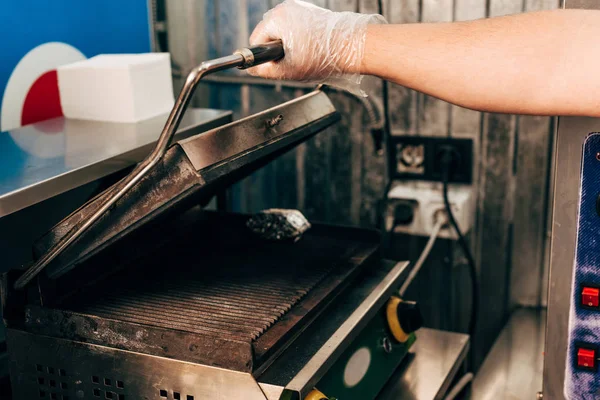 Abgeschnittene Ansicht von Koch in Handschuh öffnet Dönergrill in Küche — Stockfoto