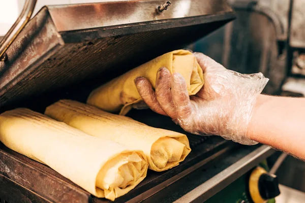 Vista recortada de cocinero en guante preparando doner kebabs en parrilla de kebab - foto de stock