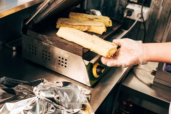 Vista recortada de cocinero en guante preparando doner kebabs en parrilla de kebab - foto de stock