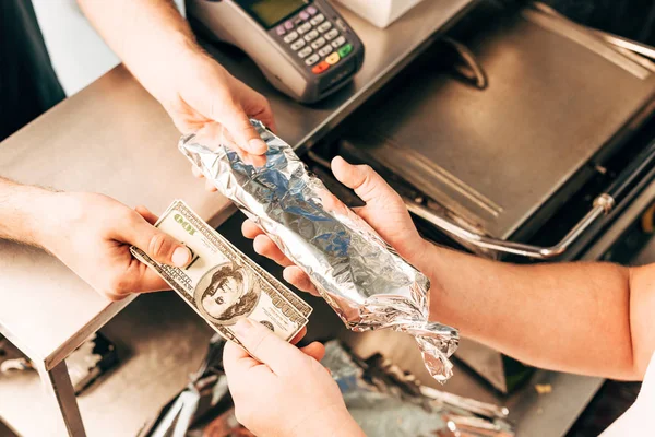 Cropped view of man buying doner kebab in aluminium foil — Stock Photo