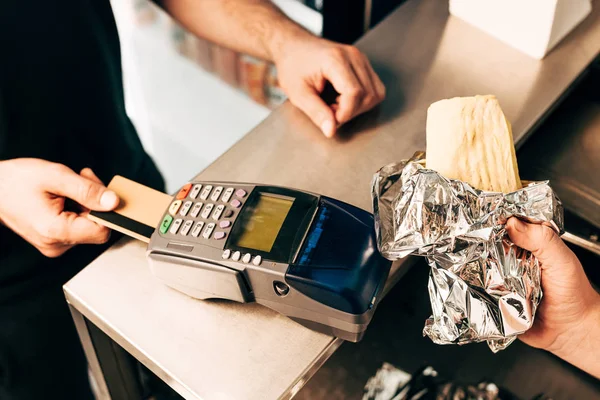 Cropped view of man buying doner kebab in aluminium foil — Stock Photo