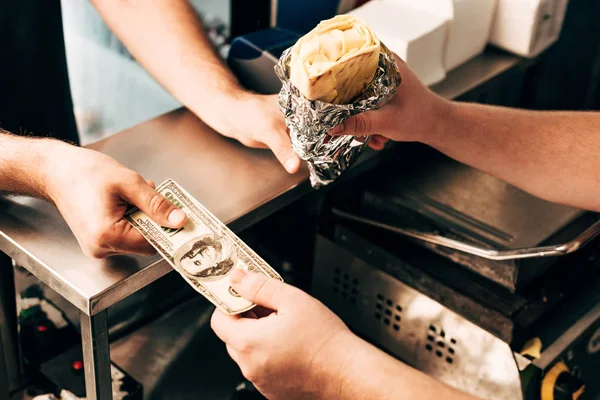 Cropped view of man buying doner kebab in aluminium foil — Stock Photo