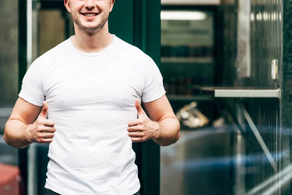 Vue recadrée de l'homme souriant montrant les pouces vers le haut — Photo de stock