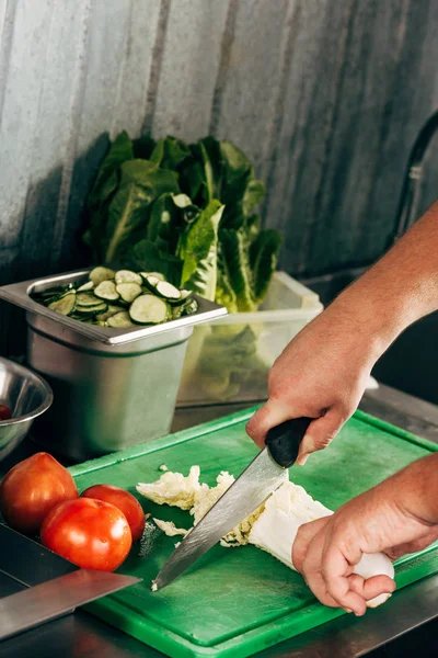 Частичный вид салата для резки повара на доске — стоковое фото
