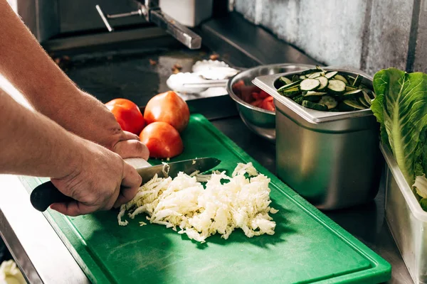 Teilansicht Koch schneidet Salat auf Schneidebrett — Stockfoto