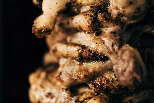 Close up view of delicious meat on rotisserie isolated on black — Stock Photo