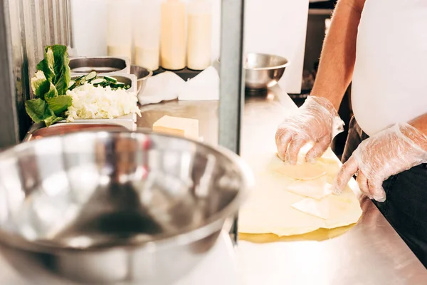 Vista recortada de cocinero en guantes preparación doner kebab - foto de stock