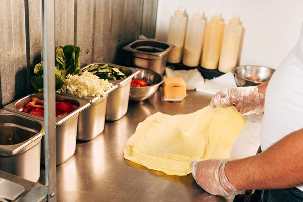 Teilansicht von Koch in Handschuhen bei der Zubereitung von Dönerspießen — Stockfoto