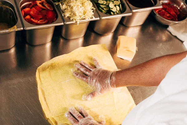 Teilansicht von Koch in Handschuhen bei der Zubereitung von Dönerspießen — Stockfoto
