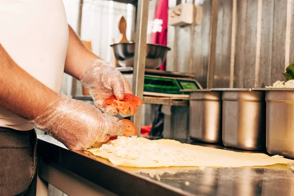 Vista parcial de cocinero en guantes preparando doner kebab - foto de stock