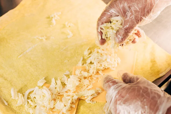 Vista recortada de cocinero en guantes preparación doner kebab - foto de stock