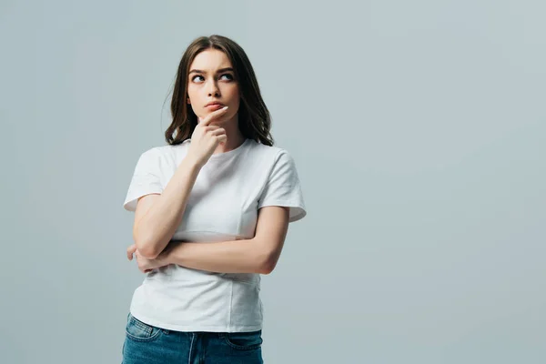 Ernsthafte nachdenkliche schöne Mädchen in weißem T-Shirt, das isoliert auf grau wegschaut — Stockfoto
