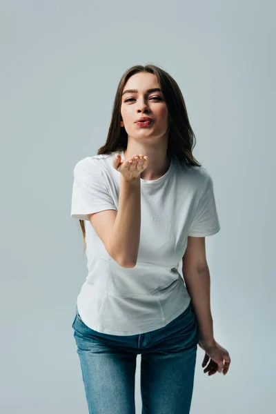 Belle fille en t-shirt blanc soufflant baiser isolé sur gris — Photo de stock