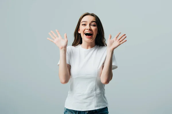 Aufgeregt glücklich schönes Mädchen in weißem T-Shirt isoliert auf grau — Stockfoto