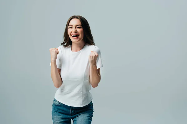 Animado menina bonita feliz em t-shirt branca mostrando sim gesto isolado em cinza — Fotografia de Stock