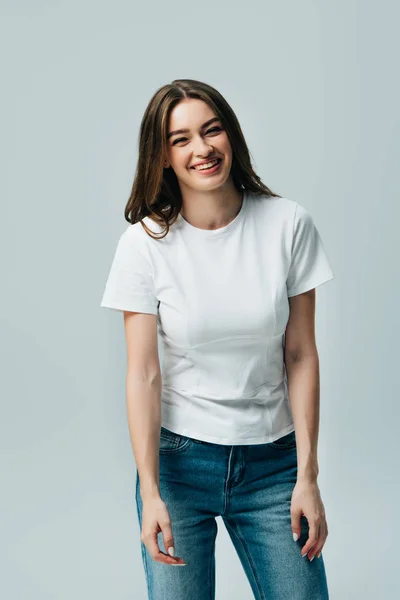 Felice ridendo bella ragazza in t-shirt bianca isolata su grigio — Foto stock