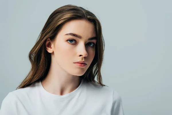 Menina bonita triste em t-shirt branca olhando para a câmera isolada no cinza — Fotografia de Stock