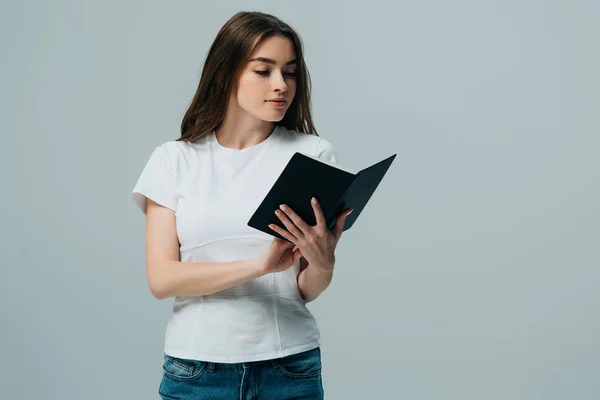 Schönes Mädchen in weißem T-Shirt liest Buch isoliert auf grau — Stock Photo