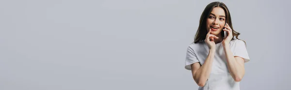 Rusée belle fille en t-shirt blanc parlant sur smartphone isolé sur gris, plan panoramique — Photo de stock