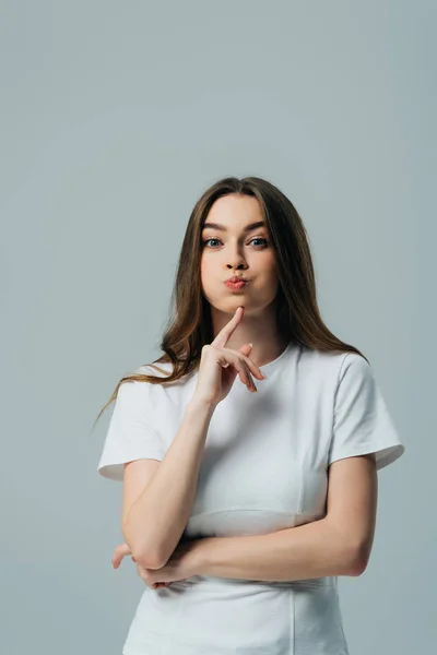 Beautiful funny girl blowing cheeks isolated on grey — Stock Photo