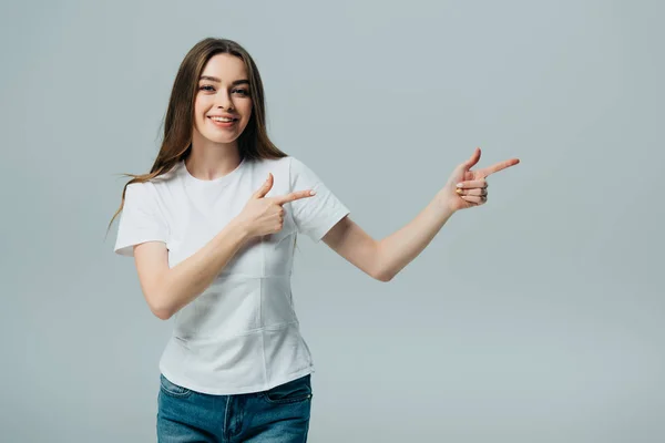 Bella ragazza felice che punta con le dita a spazio copia isolato su grigio — Foto stock