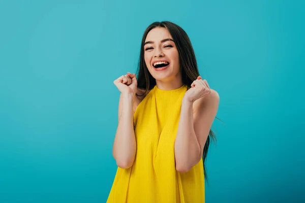 Glücklich schönes Mädchen in gelbem Kleid zeigt Ja-Geste isoliert auf Türkis — Stockfoto