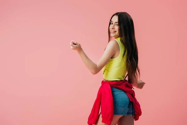 Sexy beautiful smiling girl in bright clothes dancing isolated on pink — Stock Photo