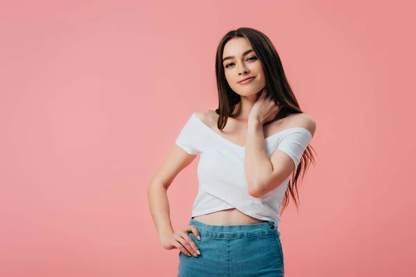 Hermosa chica sonriente posando con la mano en la cadera aislado en rosa - foto de stock