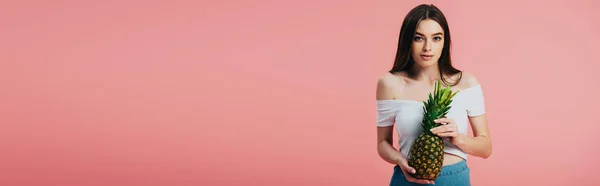 Beautiful girl holding ripe delicious pineapple isolated on pink, panoramic shot — Stock Photo