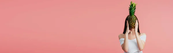 Ragazza che tiene maturo delizioso ananas davanti al viso isolato su rosa, colpo panoramico — Foto stock