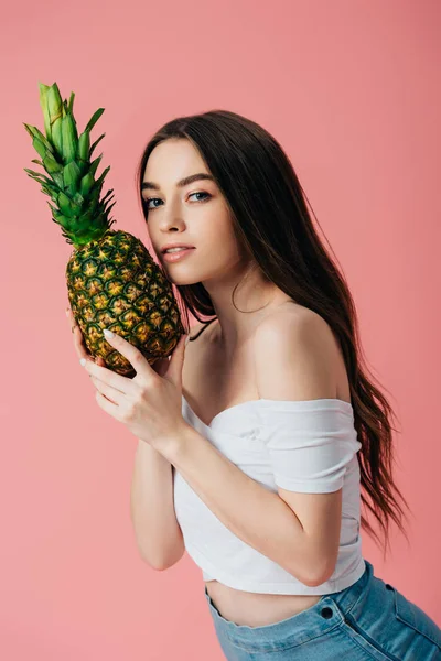 Schönes Mädchen posiert mit reifen köstlichen Ananas isoliert auf rosa — Stockfoto
