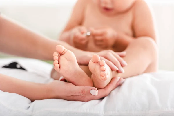 Vista ritagliata di madre che tocca i piedi su piccola figlia — Foto stock