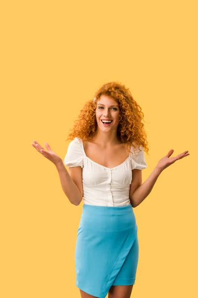 Счастливая рыжеволосая женщина с жёстким жестом, изолированная на желтом — стоковое фото