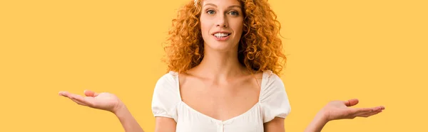 Mujer sonriente con gesto de encogimiento, aislada en amarillo - foto de stock