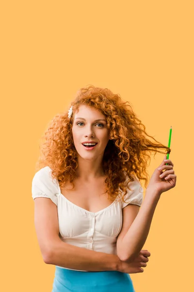 Chica pelirroja conmocionada con lápiz aislado en amarillo - foto de stock