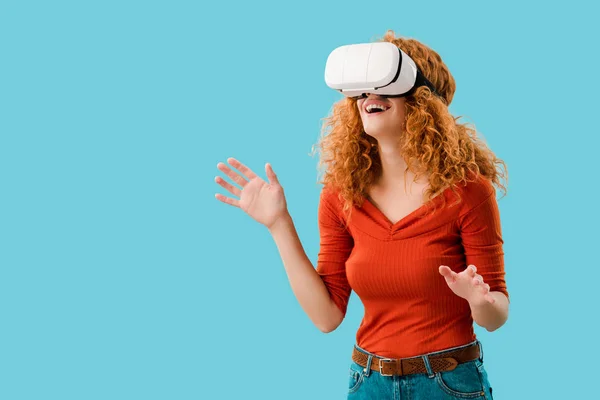 Hermosa mujer sonriendo en realidad virtual auriculares aislados en azul - foto de stock