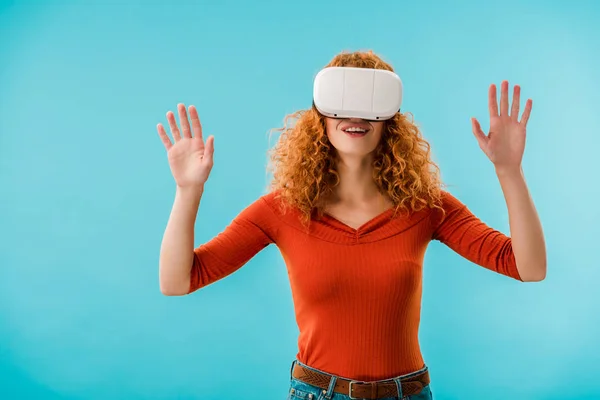 Rothaarige Frau gestikuliert in Virtual-Reality-Headset isoliert auf blau — Stockfoto