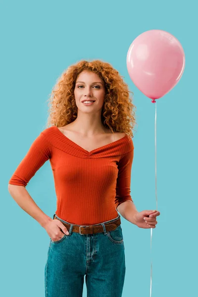 Junge rothaarige Frau mit rosa Ballon isoliert auf blau — Stockfoto