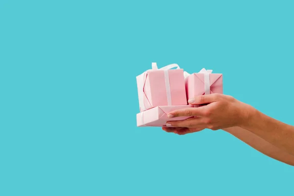 Cropped view of girl holding presents in hands isolated on blue — Stock Photo