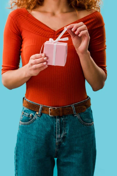 Vista recortada de la mujer sosteniendo caja de regalo aislado en azul - foto de stock