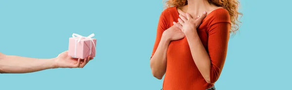 Vista recortada de mujer pelirroja con caja de regalo aislado en azul - foto de stock