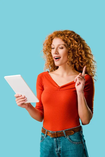 Beautiful woman having idea while using digital tablet isolated on blue — Stock Photo