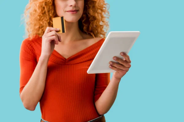 Обрізаний вид жінки покупки в Інтернеті з цифровим планшетом і кредитною карткою ізольовані на синьому — стокове фото