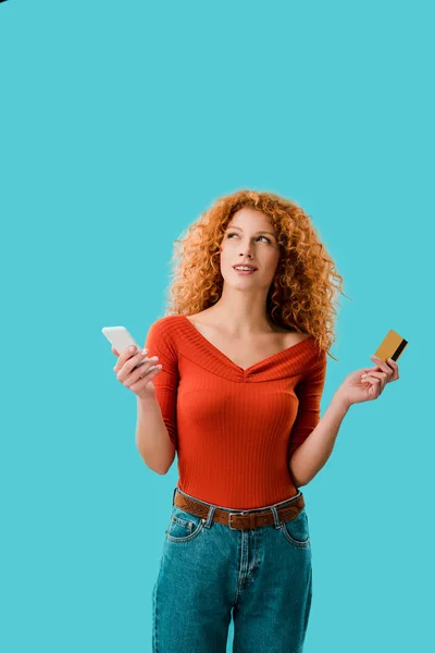 Mujer pensativa de compras en línea con tableta digital y tarjeta de crédito aislada en azul - foto de stock