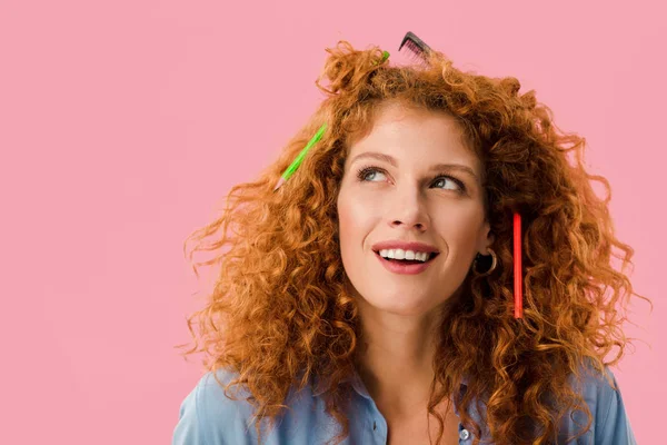 Redhead woman with pencils in hair isolated on pink — Stock Photo