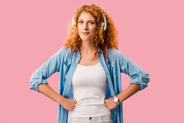 Curly redhead woman listening music in headphones, Isolated On pink — Stock Photo